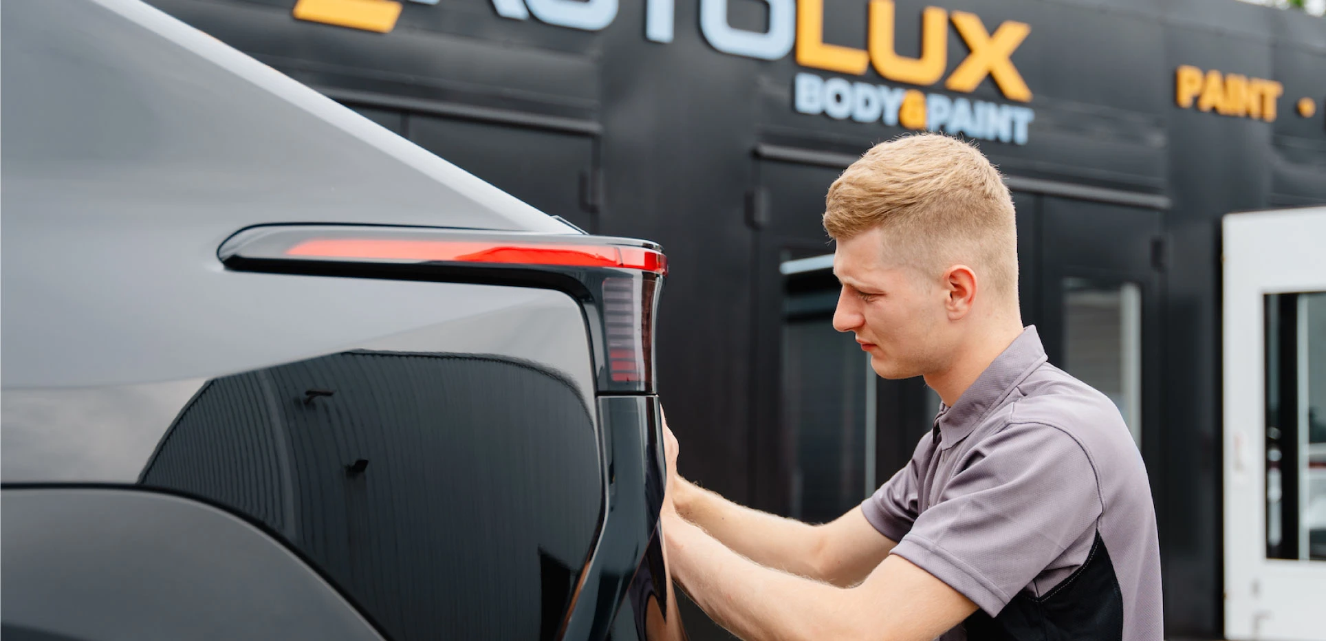 AutoLux employee working at the back of a car